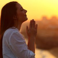 66472-woman-praying-sunset-gettyimages-antonioguill.1200w.tn_-800×418-1